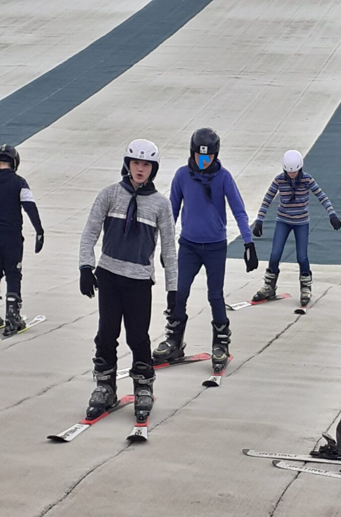 Group practising skiing on a dry ski slope.