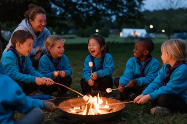 Beaver Scouts aged six to eight enjoying a supervised campfire in turquoise uniforms